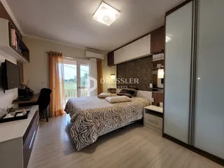 Quarto com cama e janela de madeira.