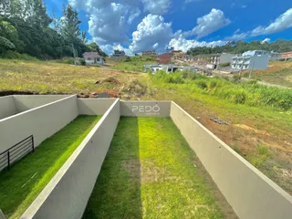 Vista de um terreno com muros delimitando uma área gramada.