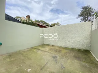 Parede externa de uma propriedade em Lajeado, Brasil, com piso de concreto no primeiro plano.