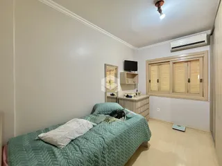 Quarto com cama e armário de madeira em um apartamento.