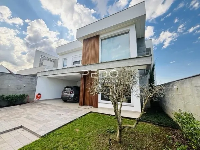 Fachada moderna de uma residência com área externa pavimentada em Lajeado.