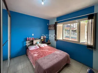 Quarto com paredes azuis e cama rosa em um imóvel no Brasil.