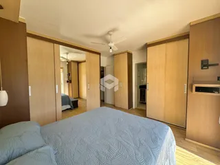 Quarto com armários de madeira e cama.