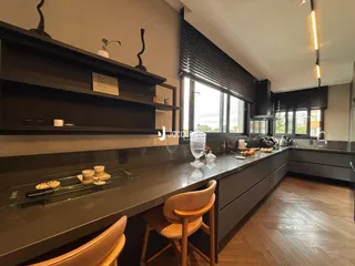 Vista da cozinha moderna com armários escuros e grande janela.