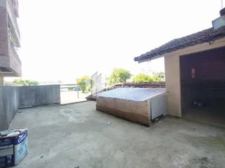 Vista externa de uma área de concreto ao lado de uma estrutura em Lajeado.