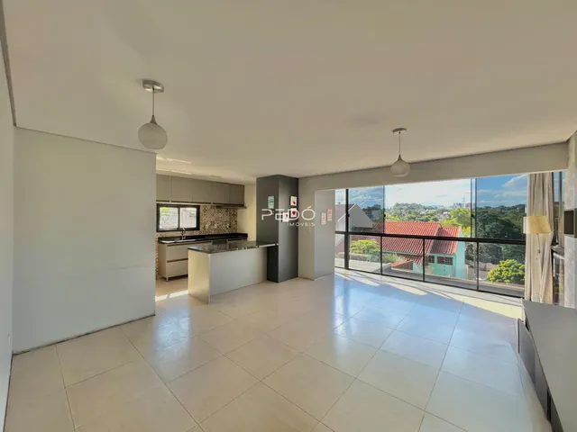 Ambiente de sala de estar e cozinha com piso de cerâmica em uma residência.