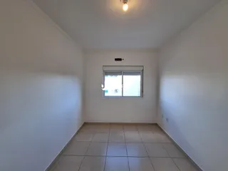 Ambiente interno de uma sala com paredes brancas e piso de cerâmica.