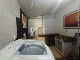 Interior de um cômodo com paredes brancas e piso de cerâmica.