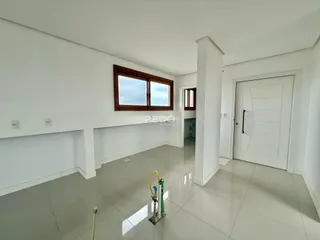 Vista interna de uma sala com paredes brancas e piso claro.