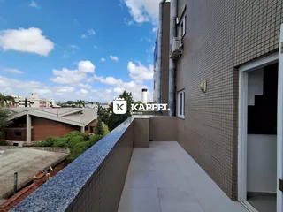 Vista externa de um terraço com piso claro e parede de tijolos em Lajeado.