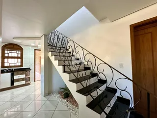 Hall de entrada com escadaria de ferro na residência.