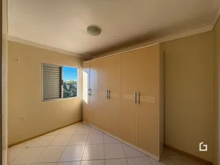 Um corredor interno com armários embutidos e piso de cerâmica claro.