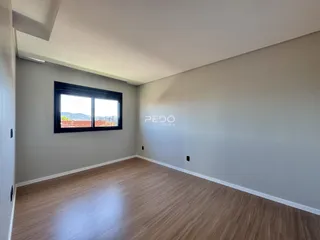 Sala de estar com piso de madeira e grande janela.