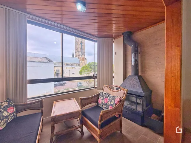 Sala de estar com vista para a rua e lareira.