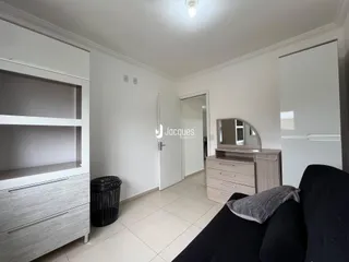 Sala de estar com paredes brancas e piso de cerâmica clara.