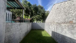 Vista externa de um terreno delimitado por muros e gramado.