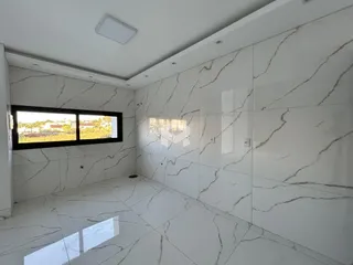 Sala de um imóvel em Lajeado, Brasil, com piso e paredes em mármore branco.