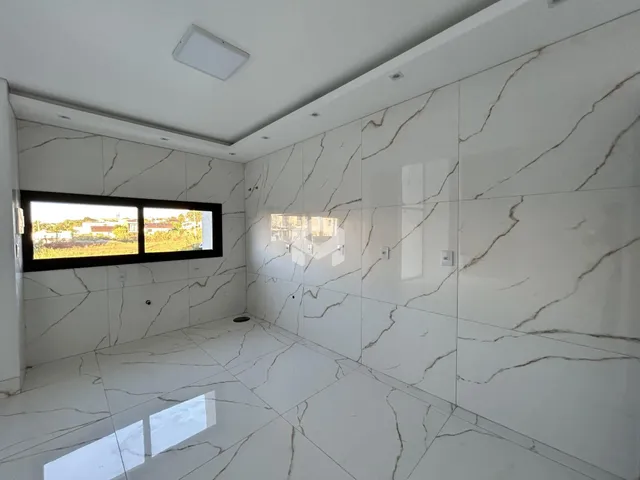 Sala de um imóvel em Lajeado, Brasil, com piso e paredes em mármore branco.