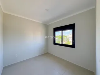 Vista interna de um cômodo com paredes brancas e piso claro.
