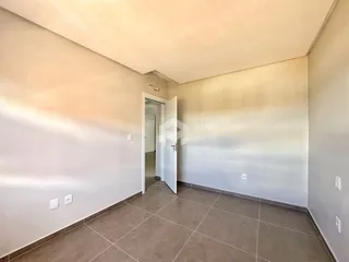 Hall de entrada com piso de cerâmica e paredes brancas.