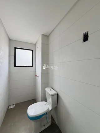 A foto mostra um corredor com um banheiro moderno.