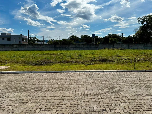 Foto da fachada de uma propriedade com um campo gramado à frente.