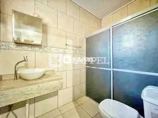 Foto de um banheiro com pia e revestimento de azulejos brancos.
