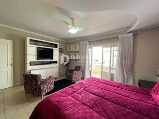 Quarto com cama grande e poltronas decorativas.