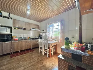 Foto de uma cozinha com armários e mesa de jantar em um imóvel no Brasil.