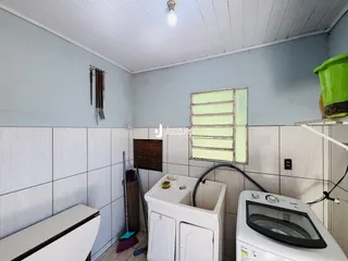Interior de um cômodo com paredes brancas e piso cerâmico.