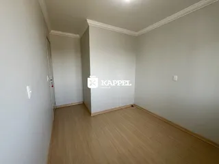 Foto de um cômodo interno com paredes brancas e piso de madeira clara.