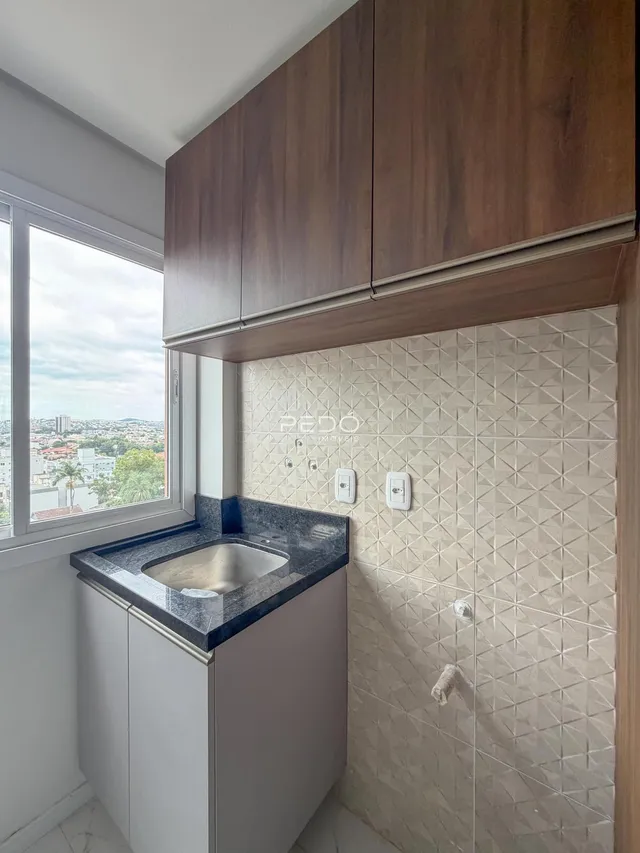 Foto de um banheiro com revestimento geométrico e janela com vista da cidade.