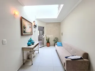 Sala de estar com paredes brancas e piso claro.