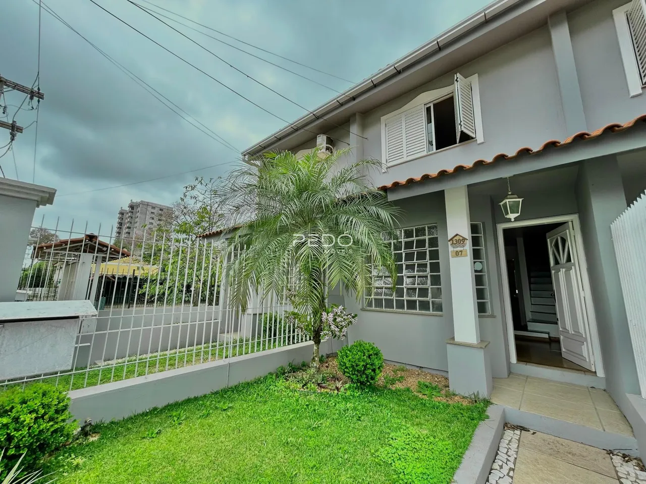 Fachada de uma residência em Lajeado, Brasil, com jardim frontal e cerca.