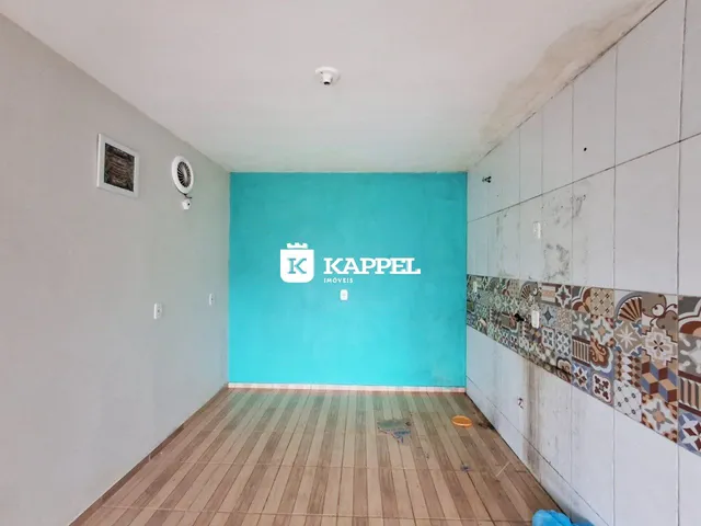 Sala de estar com piso de madeira clara e uma parede de destaque azul turquesa.