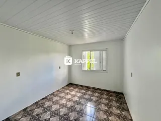 Ambiente interno com piso de ladrilhos e janela.