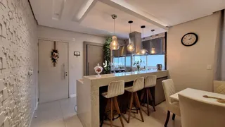 Uma cozinha moderna com ilha e área de jantar em um apartamento.