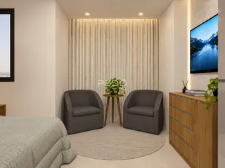 Sala de estar moderna com dois poltronas e uma televisão.