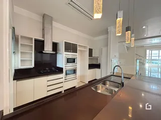 Cozinha moderna com armários brancos e bancada escura.