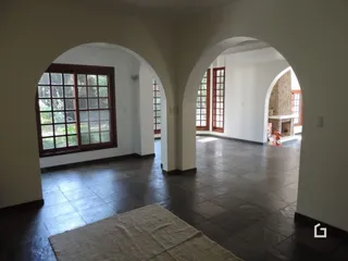 Hall de entrada com piso de cerâmica escura e paredes brancas.