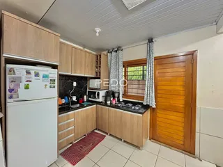 Foto de uma cozinha com armários de madeira e bancadas escuras.