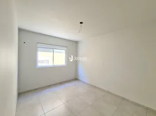 Vista interna de uma sala com piso de cerâmica e janela.