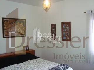 Foto de um quarto com cama e quadros na parede.