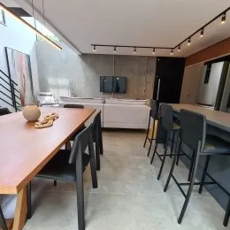 Foto de uma mesa de jantar de madeira em um ambiente interno.