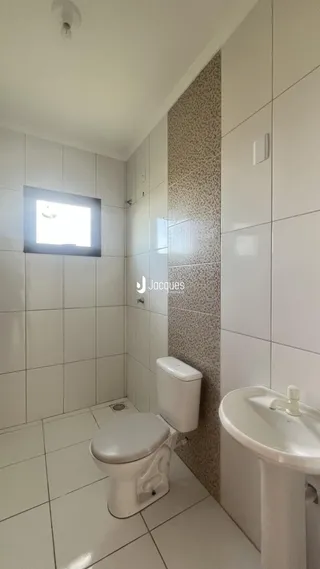 Foto de um banheiro com revestimento cerâmico branco.