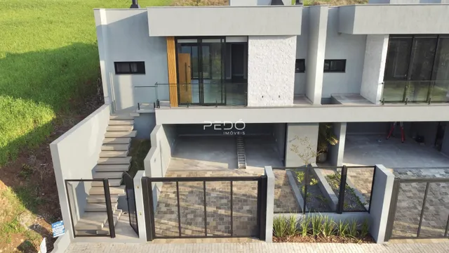 Fachada de uma residência moderna com acesso por escadaria e área externa.