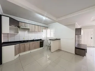 Foto de uma cozinha moderna com armários brancos e piso de cerâmica claro.