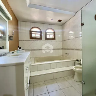 Foto de um banheiro com revestimento cerâmico e banheira.