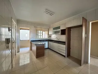 Imagem de uma cozinha e área adjacente em um imóvel no Brasil.