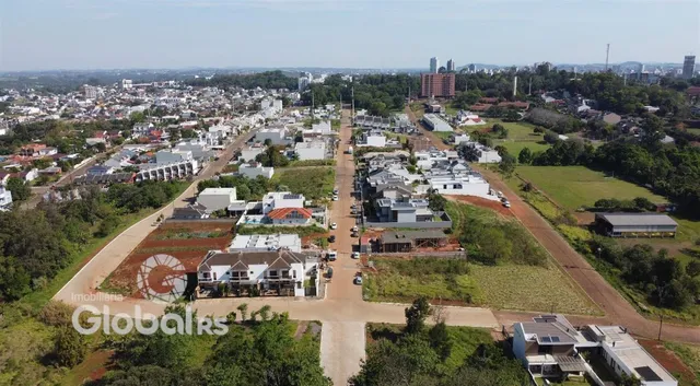 Vista aérea de uma área residencial com terrenos e vegetação no Brasil.